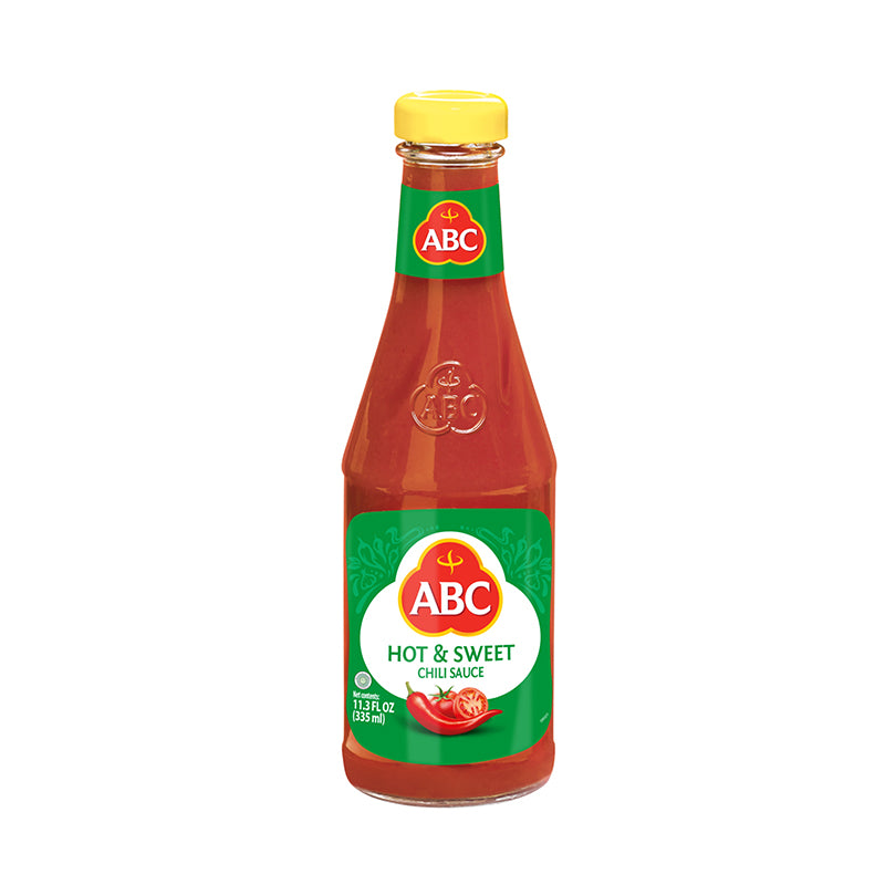 ABC Hot & Sweet Chili sauce in a glass bottle. Tomatoes and fresh chilies are pictured.