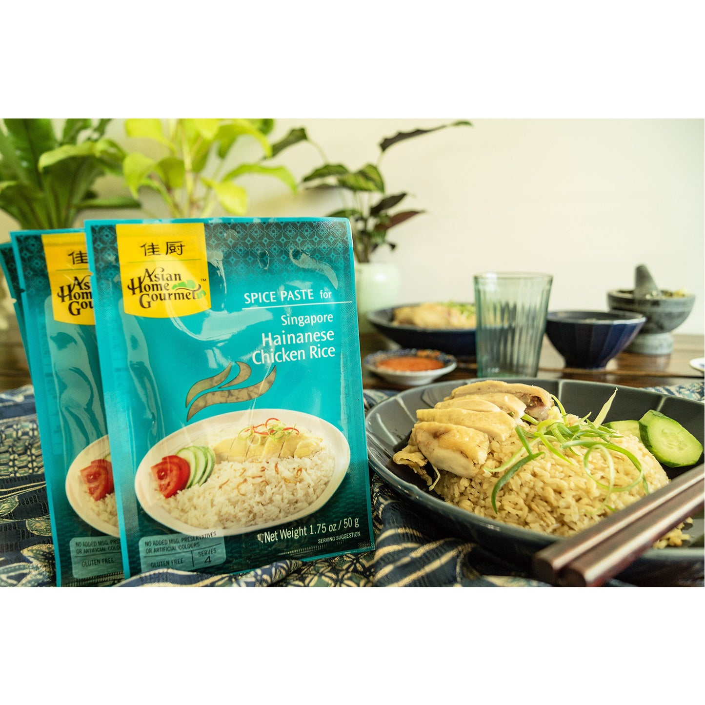 Lifestyle photograph of Hainanese sachets. A bowl of hainan rice and steamed chicken with chopsticks is pictured.