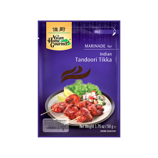 Asian Home Gourmet marinade for Indian tandoori tikka in purple 1.75 oz sachet. Grilled chicken in skewers with a side of pickled veggies, lettuce, and limes are pictured on a plate. Sachet is labeled mild level of spiciness.